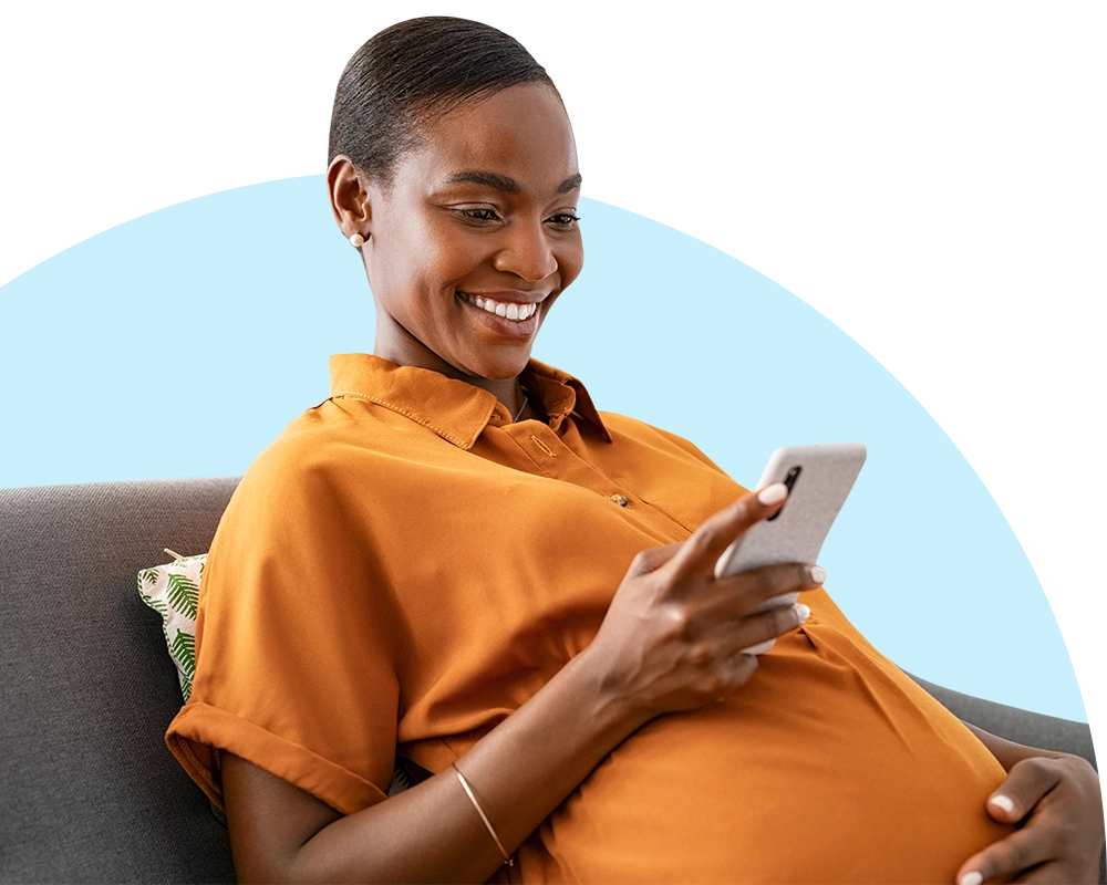expecting mother on a couch looking at her phone.